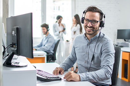 Happy,young,male,customer,support,executive,working,in,office.